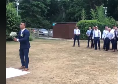 مقطع فيديو ساخر لرجل يمسك بالزهور ويلقيها على اصدقائه اثناء عرسه