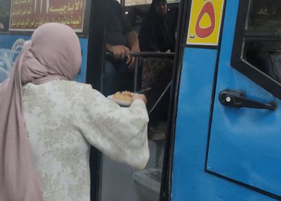 «أم إسلام» توزع الوجبات على ركاب أوتوبيس
