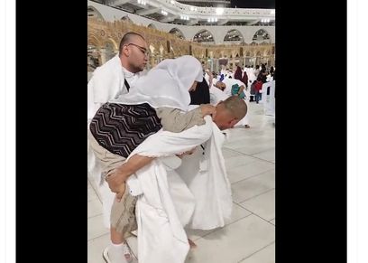 شاب يحمل والدته على ظهره