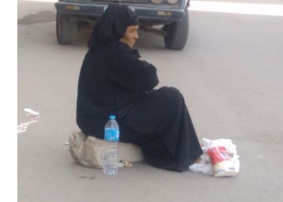 عجوز تفترش الرصيف لبيع حصتها التموينية