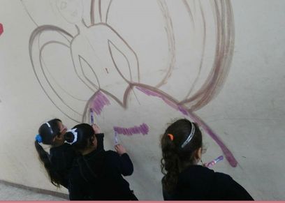 طالبات ترسم عروس على حائط المدرسة