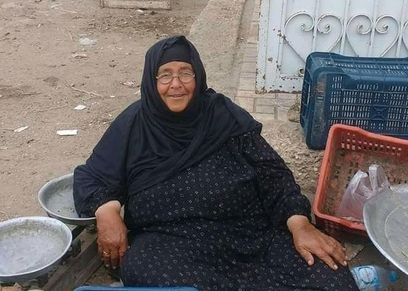 «آمنة» بائعة الفاكهة تجلس فى سوق بالبرلس