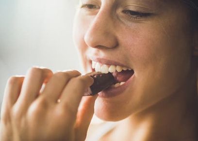 فتاة تتناول قطعة شيكولاتة