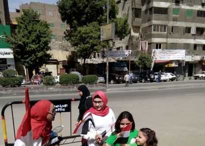 أم تصطحب بناتها الثلاث لتعليهم الوطنية