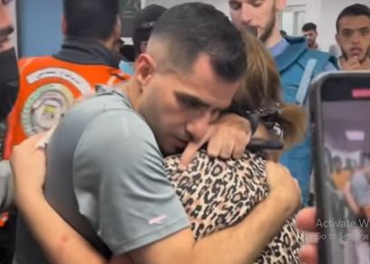 شاب فلسطيني يحتضن والدته فجأة بعد قصف كنيسة الروم الأرثوذكس
