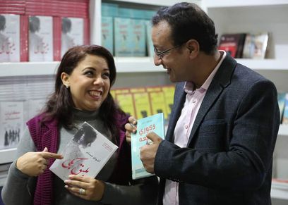 زوجان يشتركا في فاترينة واحدة بمعرض الكتاب