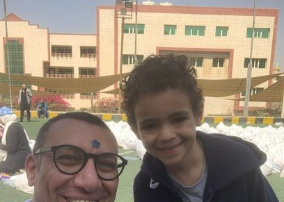 الطفل محمد مع هيثم التابعي مؤسس «أبواب الخير»
