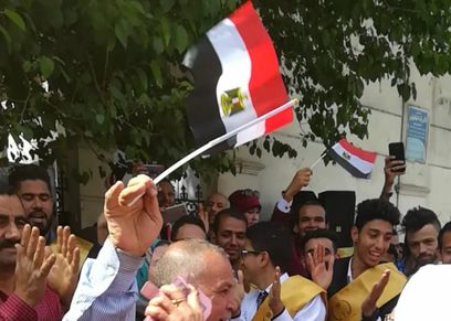 سيدة تنافس زوجها في الرقص أمام اللجان الانتخابية