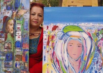 الفنانة التشكيلية السورية عتاب حريب وسط لوحاتها