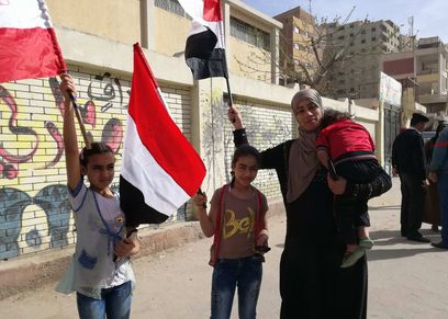 أم وأطفالها بعلم مصر خلال مشاركتها في الانتخابات: 