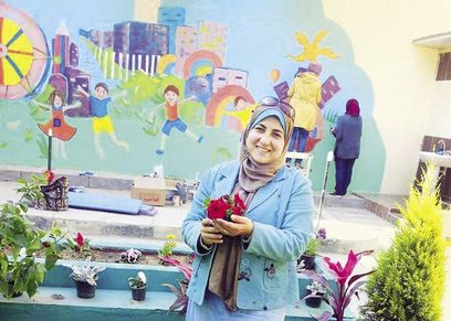 «شوق» ممسكة بإحدى الشتلات
