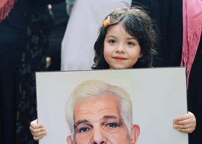 طفلة تحمل صورة جدها في إفطار المطرية