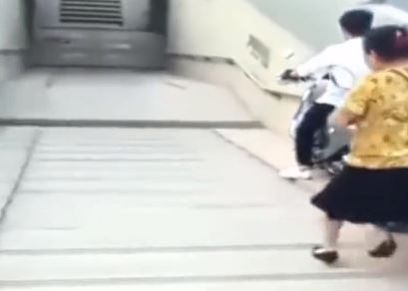 مرأة تسقط على الأرض بعد نزول دراجتها من فوق السلم 