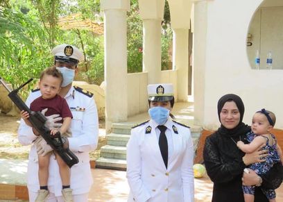أرملة الشهيد مع رجال الداخلية خلال معايدتهم عليها هى وأبناء الشهيد