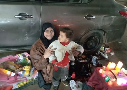 «هدى» مع طفلتها على أحد الأرصفة