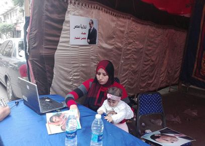 بالصور| «ولاء ورضيعتها» يساعدان الناخبين في التعرف على المقار الإنتخابية