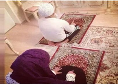صلاة الأم مع ابنها- صورة تعبيرية