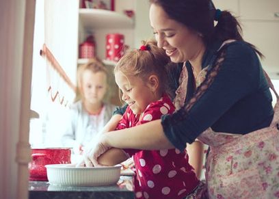 أم وبناتها تعد لهن الطعام