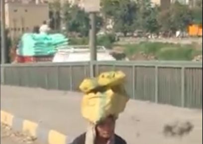 فاطمة تجمع بقاي المخلفات زحفا على كوبري السواح