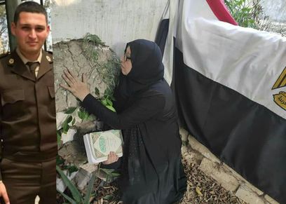 والدة الشهيد خلال زيارة قبرة