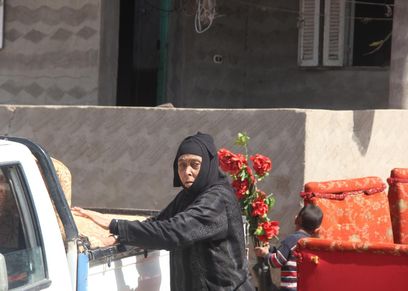 عجوز اثناء تحميلها اثاث منزلها استعدادا لمغادرة قرية الجن فى كفر الشيخ
