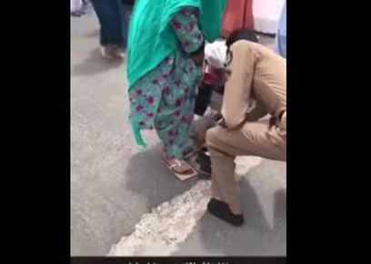 رجل أمن يخلع حذاءه لامرأة مسنة ليقيها من حرارة الأرض