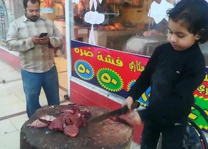الطفل عبدالله سليمان خلال عمله بالجزارة