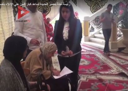 رئيسة لجنة بمصر الجديدة تساعد كبار السن علي الإدلاء بأصواتهم