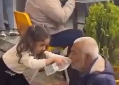 طفلة عراقية مع مسن مشرد