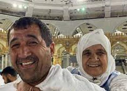 شاب يحمل والدته على ظهره