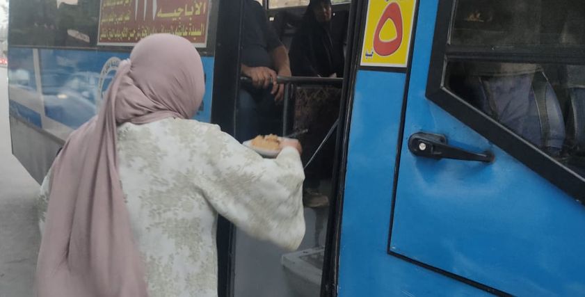 «أم إسلام» توزع الوجبات على ركاب أوتوبيس