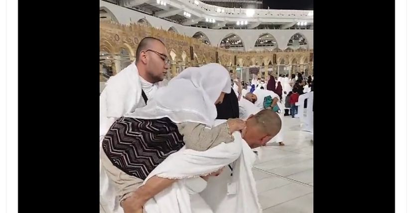 شاب يحمل والدته على ظهره