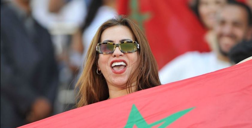 بالأعلام وأحمر الشفاه.. تألق المغربيات باستاد السلام  لمؤازرة أسود الأطلس