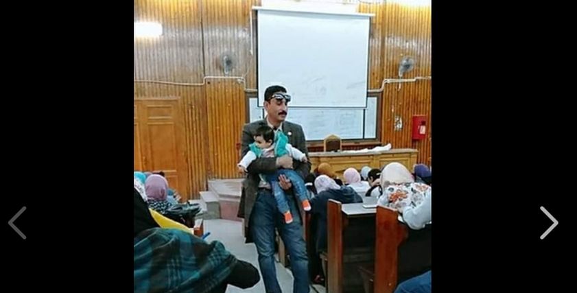 الأستاذ الجامعي يحمل الرضيعة