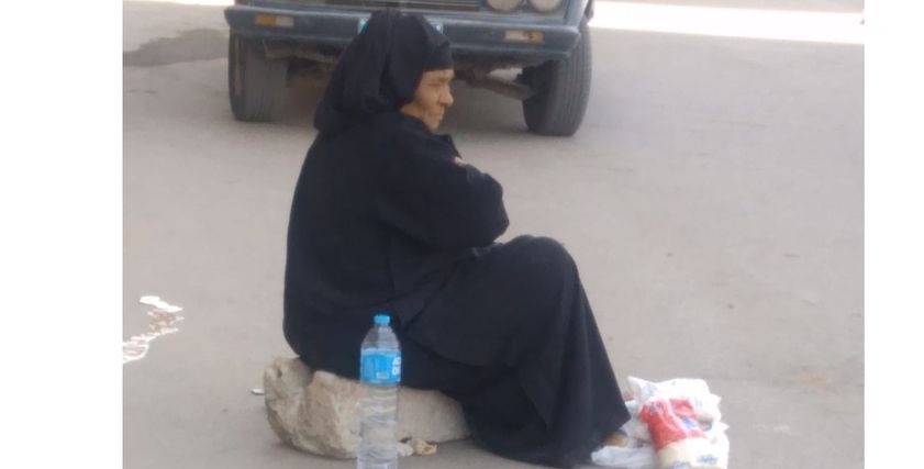 عجوز تفترش الرصيف لبيع حصتها التموينية