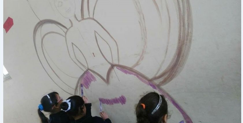 طالبات ترسم عروس على حائط المدرسة