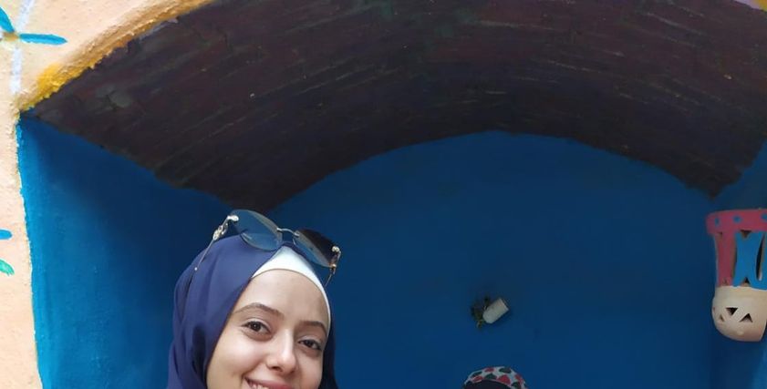 ريهام جانب إحدى لوحاتها