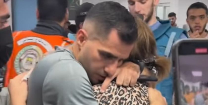 شاب فلسطيني يحتضن والدته فجأة بعد قصف كنيسة الروم الأرثوذكس
