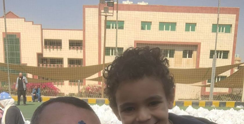 الطفل محمد مع هيثم التابعي مؤسس «أبواب الخير»