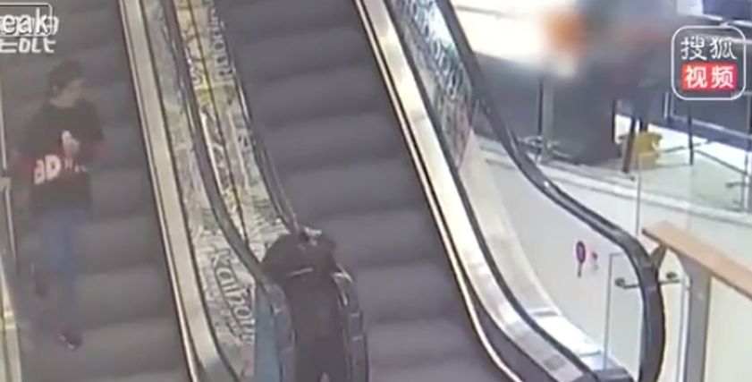 شاب يتمكن من إنقاذ فتاة قبل أن يسحبها السلم الكهربائي