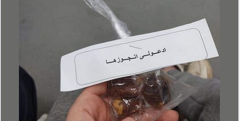 شاب يوزع على الصائمين أكياس تمر