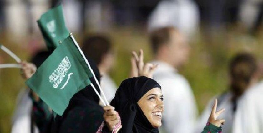 سيدات السعودية يرفع علم المملكة العربية السعودية