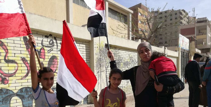 أم وأطفالها بعلم مصر خلال مشاركتها في الانتخابات: 