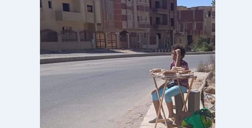 طفل يقف على طاوله لبيع السندوتشات في العبور