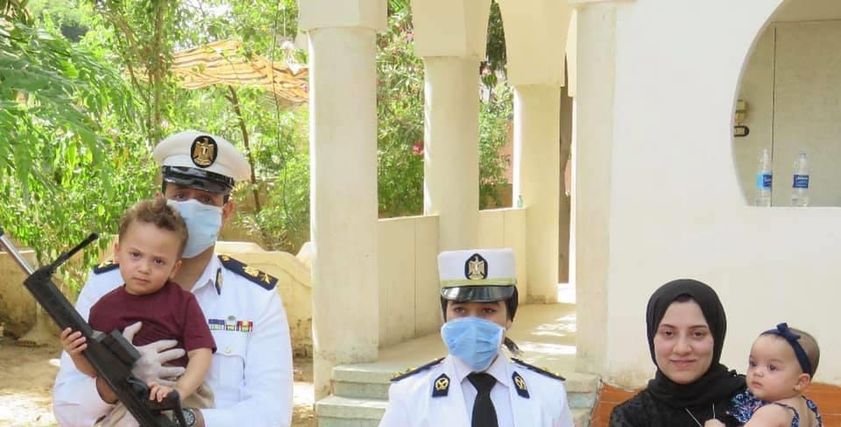 أرملة الشهيد مع رجال الداخلية خلال معايدتهم عليها هى وأبناء الشهيد