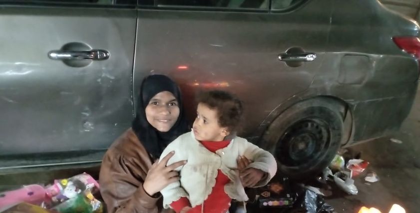 «هدى» مع طفلتها على أحد الأرصفة