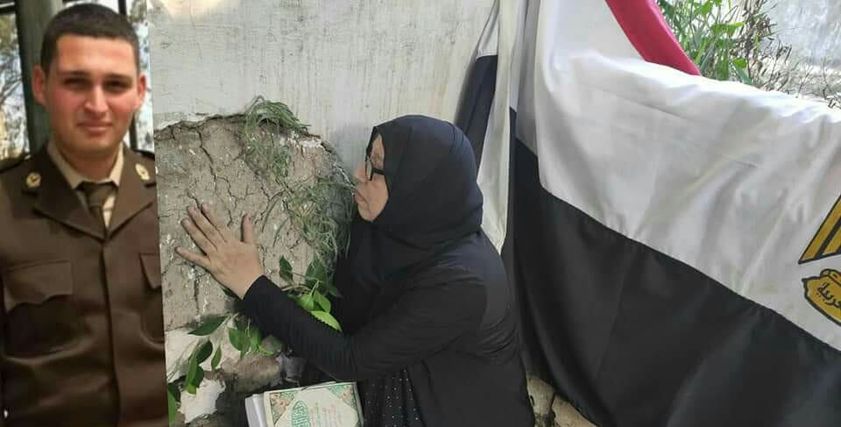 والدة الشهيد خلال زيارة قبرة