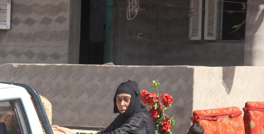 عجوز اثناء تحميلها اثاث منزلها استعدادا لمغادرة قرية الجن فى كفر الشيخ