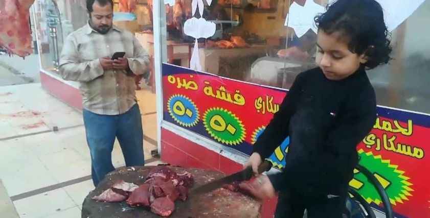 الطفل عبدالله سليمان خلال عمله بالجزارة