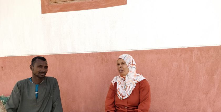 عزيزة أدم تستمع إلى أحد أهالي القرية
